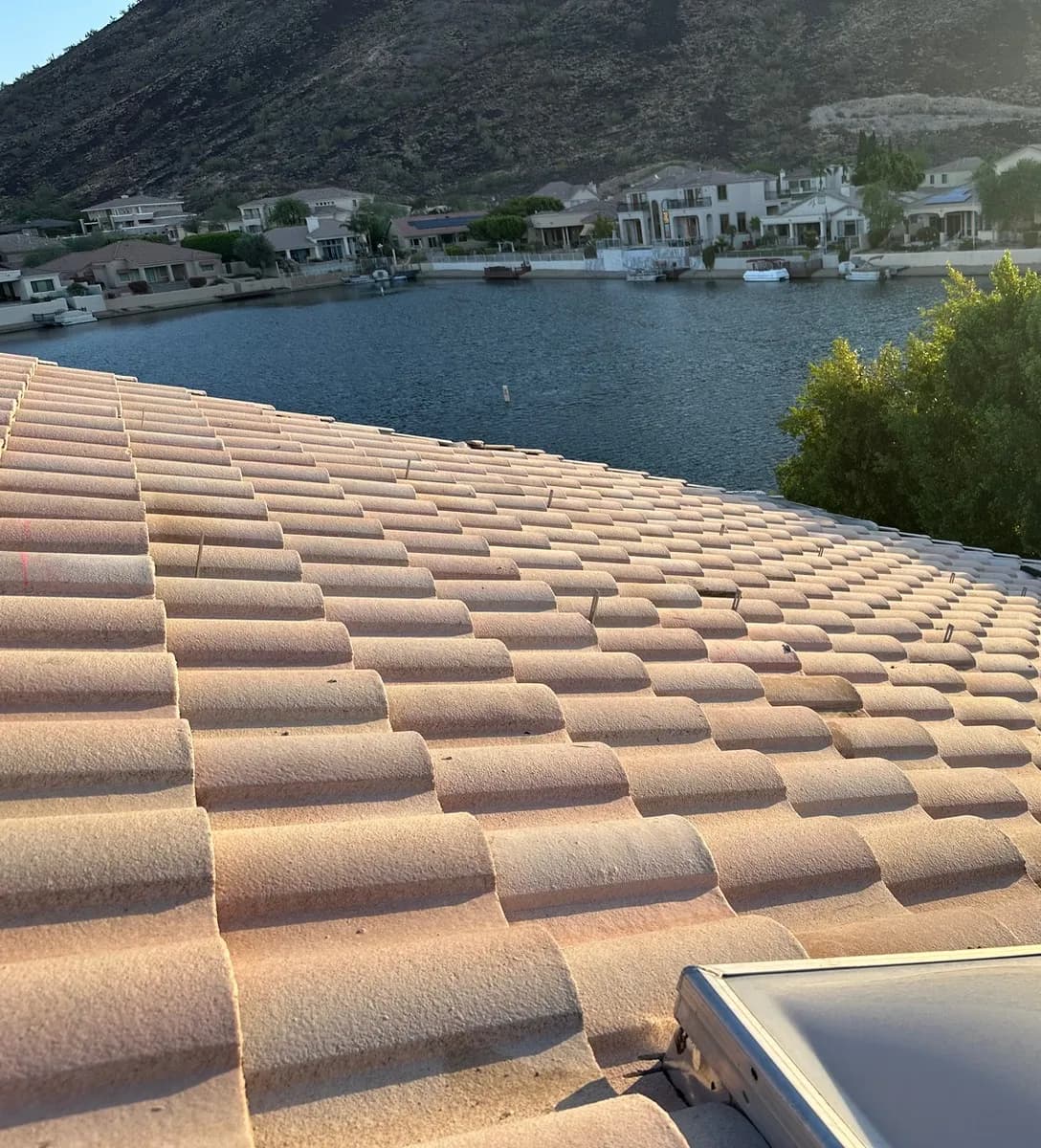 A Glendale tile roof stripped of its solar panels at golden hour, mounting feet still in place