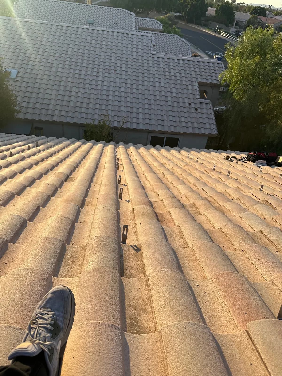 Mounting feet left in rows across a bare Glendale tile roof after the solar panels came off