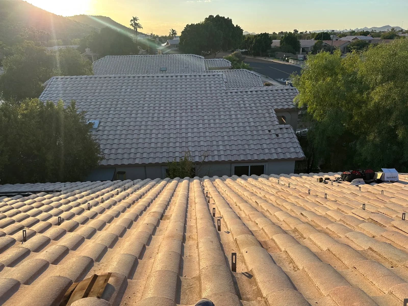 A cleared Glendale tile roof at sunset with the solar mount points exposed