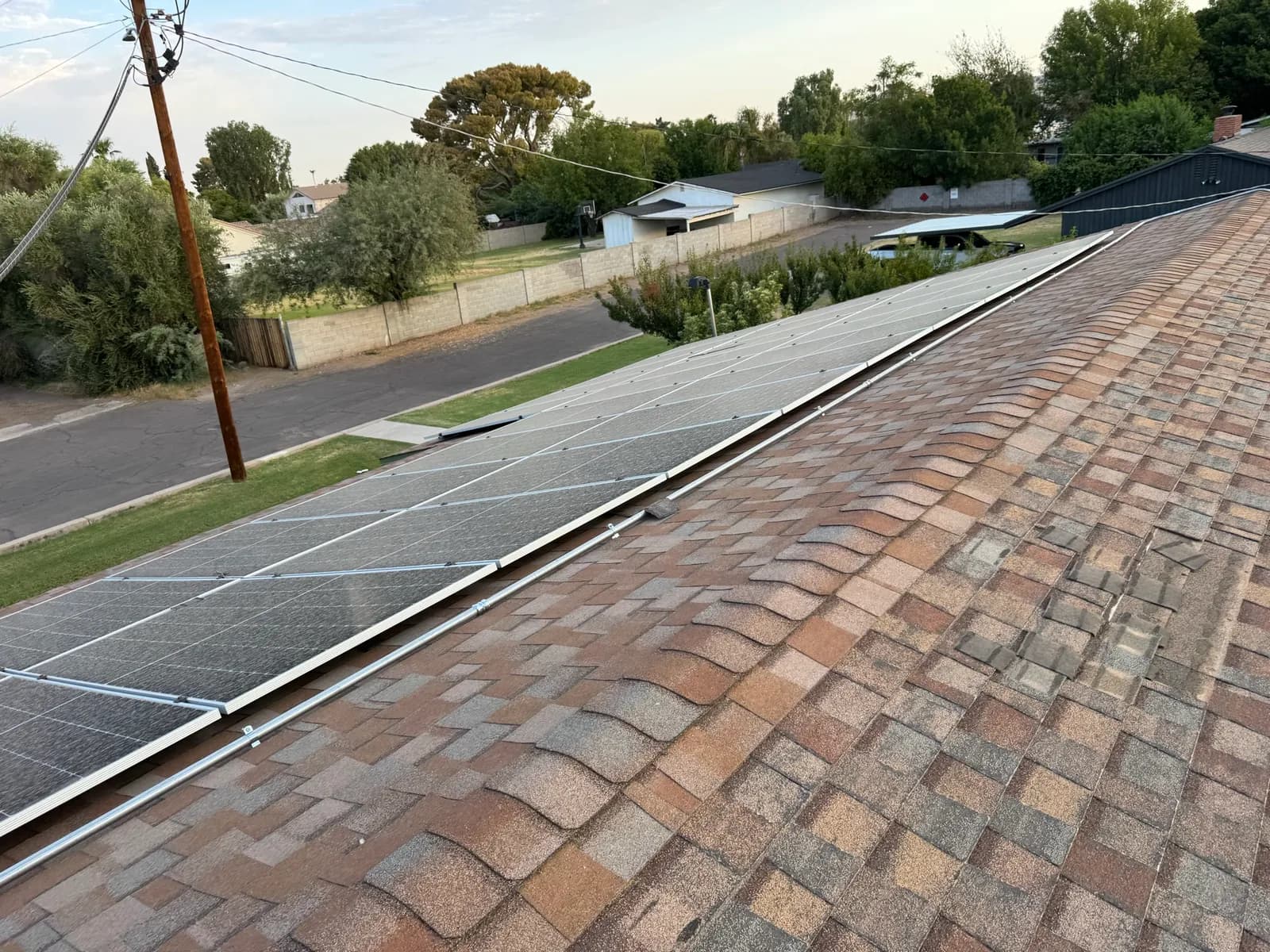 A full row of solar panels reset along the length of a Phoenix shingle roof